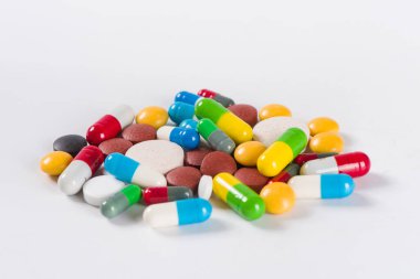 Beyaz arka planda çeşitli ilaç hapları, haplar ve kapsüller.