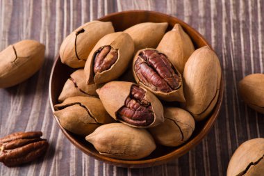 Pecan in bag on wooden table. Heap or stack of pecan . Pecan background.