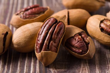 Pecan in bag on wooden table. Heap or stack of pecan . Pecan background.