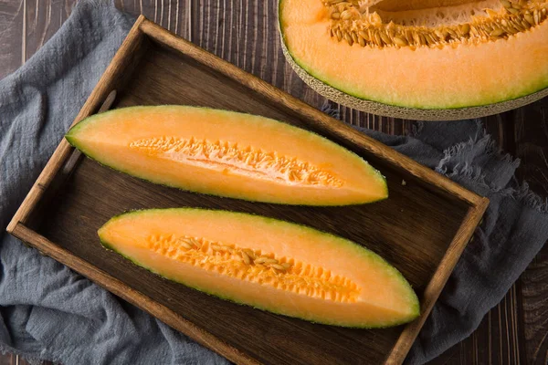 close-up of fresh Hami melon fruit on wooden background.
