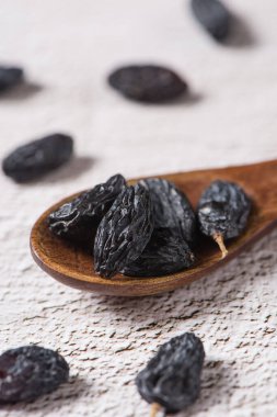 Dried fruits, pile of black raisins on table.