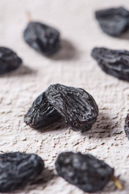 Dried fruits, pile of black raisins on table.