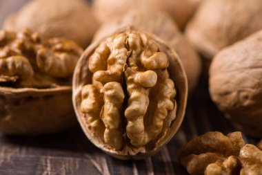 Ahşap zemin üzerinde çiğ ceviz çekirdekleri ve cevizler