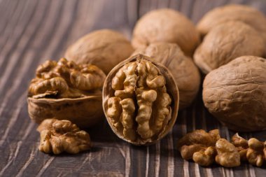 Ahşap zemin üzerinde çiğ ceviz çekirdekleri ve cevizler