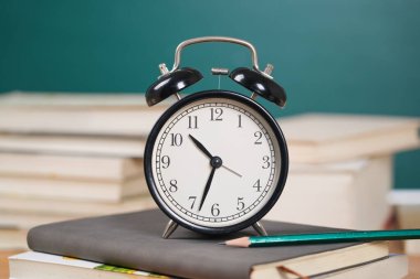 Kitap yığınındaki çalar saat