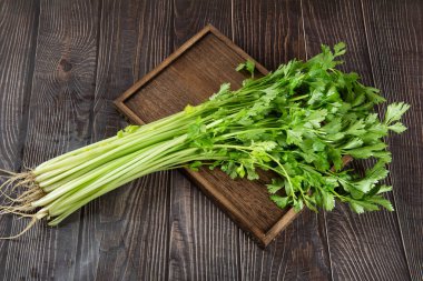 Tahta masadaki yapraklı taze kereviz..