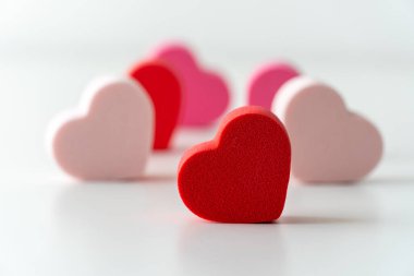 Beyaz arkaplanı olan kırmızı ve pembe kalplere yakın çekim.