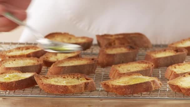 Stokbrood segmenten wordt besprenkeld met olijfolie — Stockvideo