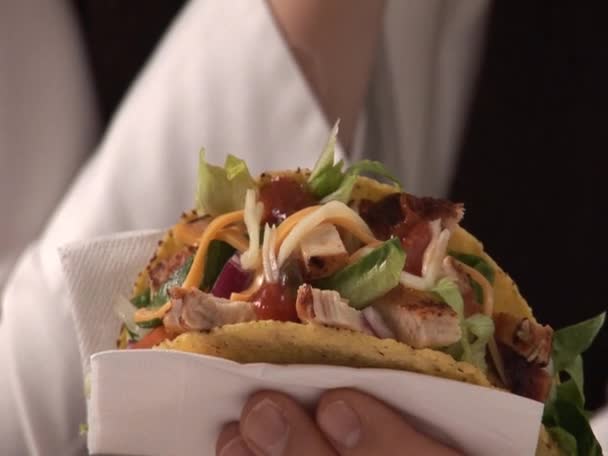 Vrouw met taco schelp gevuld met kip — Stockvideo