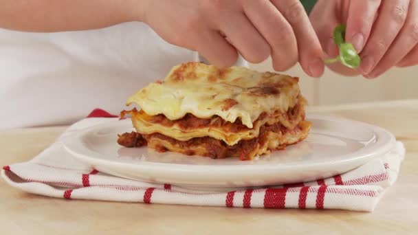 Lasagna being garnished with basil — Stock Video