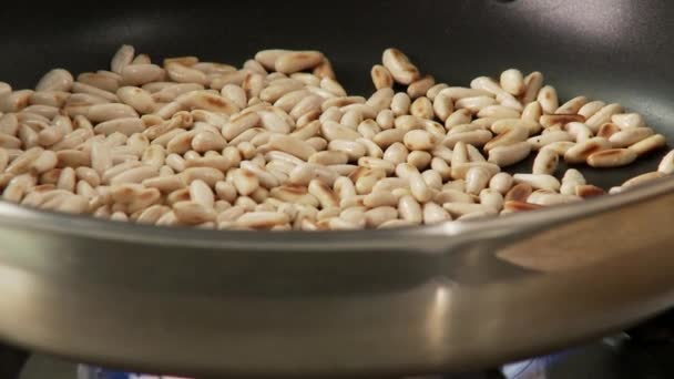 Жареные сосновые орехи в кастрюле — стоковое видео