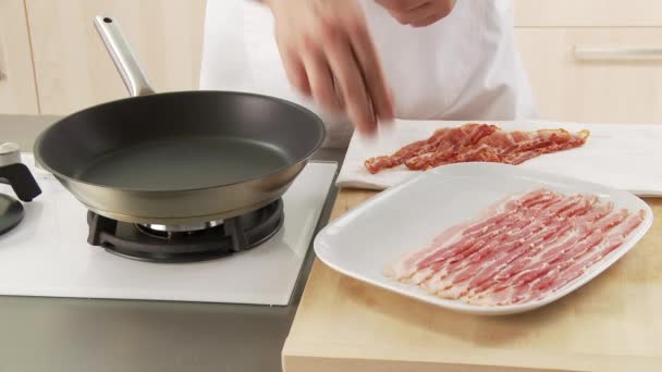 Bacon sendo colocado em uma panela — Vídeo de Stock