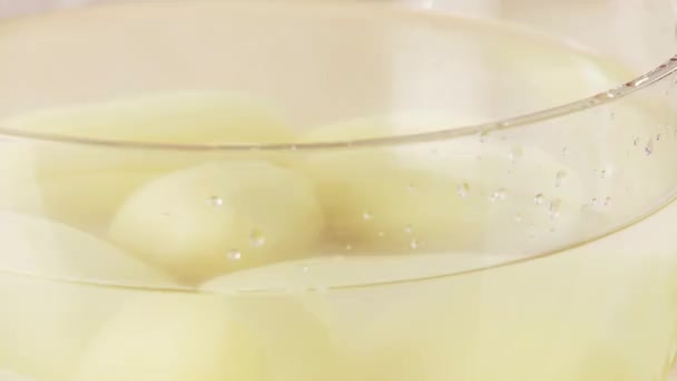 Картофель кладут в миску с водой — стоковое видео