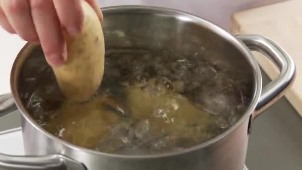 Картофель добавляется в воду — стоковое видео