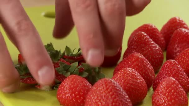 Person att ta bort strawberry lämnar — Stockvideo
