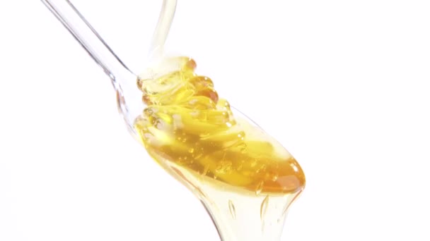 Honey running onto plastic spoon — Stock Video