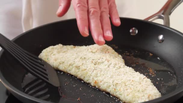 Gepaneerde schelvis in een pan — Stockvideo