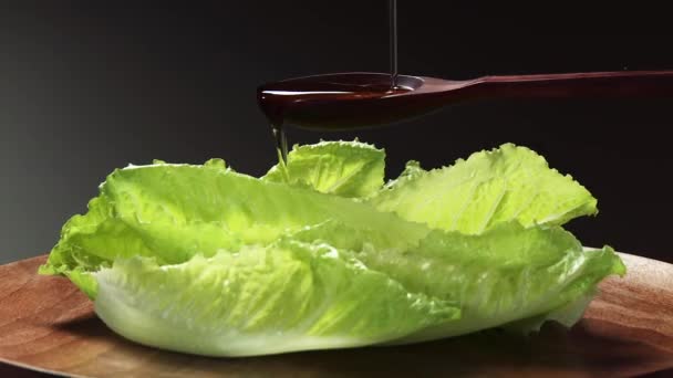 Verter aceite sobre las hojas de lechuga iceberg — Vídeo de stock