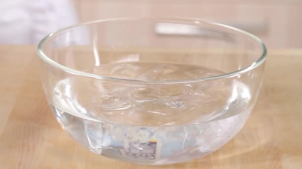Blanqueando tomates en tazón con agua — Vídeos de Stock