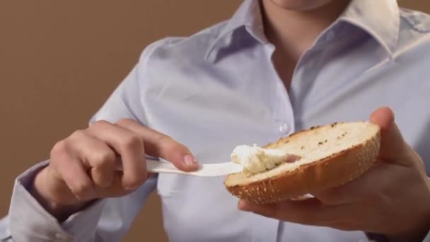 Frau verteilt Frischkäse auf Bagel — Stockvideo