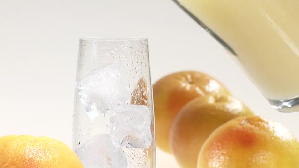 Grapefruitsaft in ein Glas Eiswürfel gießen — Stockvideo