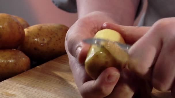 Skalar en potatis med en kniv — Stockvideo
