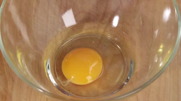 Um ovo sendo rachado em uma tigela — Vídeo de Stock