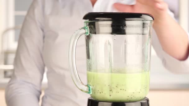 Honung som läggs till en banan och kiwi smoothie — Stockvideo