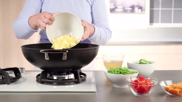 Papas y zanahorias colocadas en un wok — Vídeo de stock