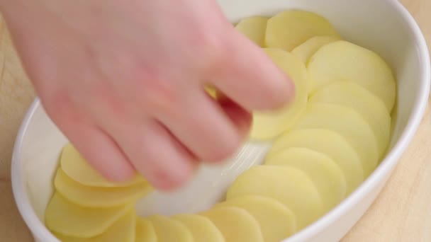 Aardappel segmenten worden gelaagde in schotel — Stockvideo