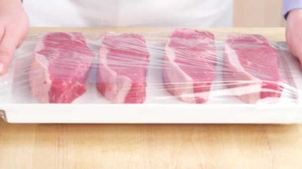 Cling film being removed from steaks — Stock Video