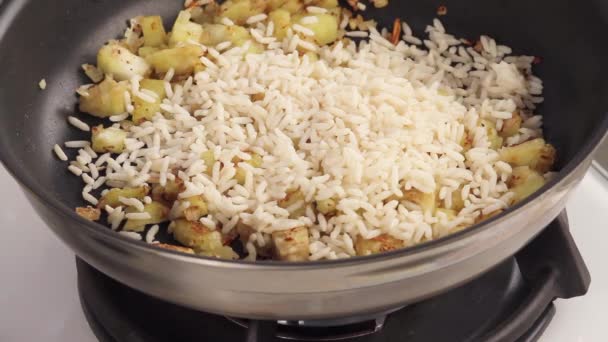 Rice being added to diced aubergine — Stock Video