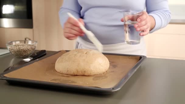 Loaf of bread brushed with water — Stock Video