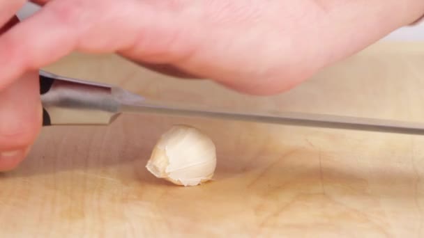 Garlic clove being crushed with a knife blade — Stock Video