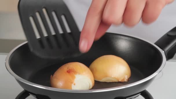 Caramelising halved onions — Stock Video