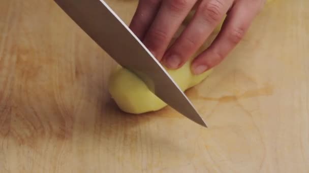 Картофель нарезают на доске — стоковое видео