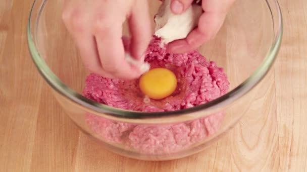 Bread being added to minced meat and egg — Stock Video