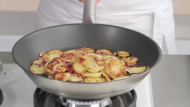 Jogando batatas refogue em uma frigideira — Vídeo de Stock