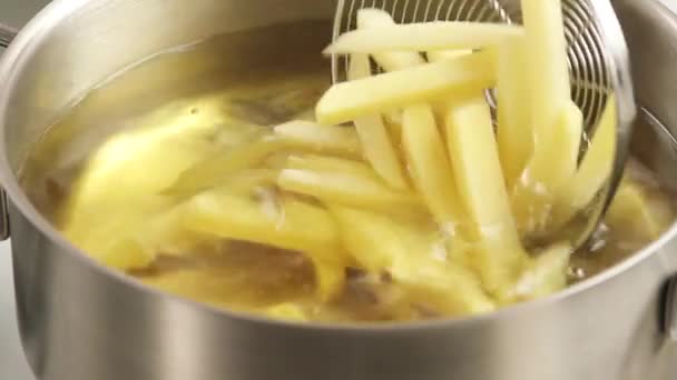 Placing chips in the deep-frying fat — Stock Video