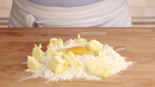 Яйцо добавляется в груду муки и масла — стоковое видео