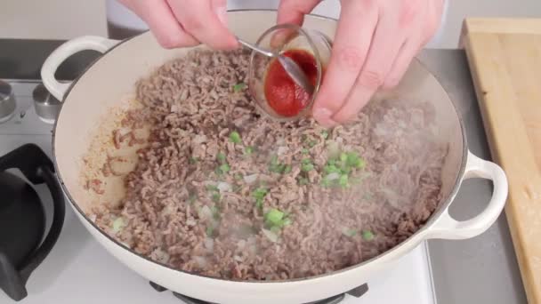 Mixing browned minced meat with tomato puree — Stock Video