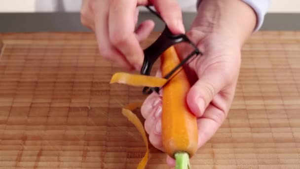Морковь чистят крупным планом — стоковое видео