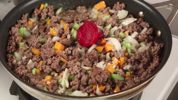 Purée de tomates ajoutée à une casserole — Video