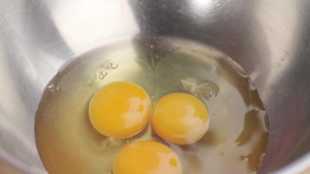 Huevos que se agrietan en un recipiente de metal — Vídeo de stock