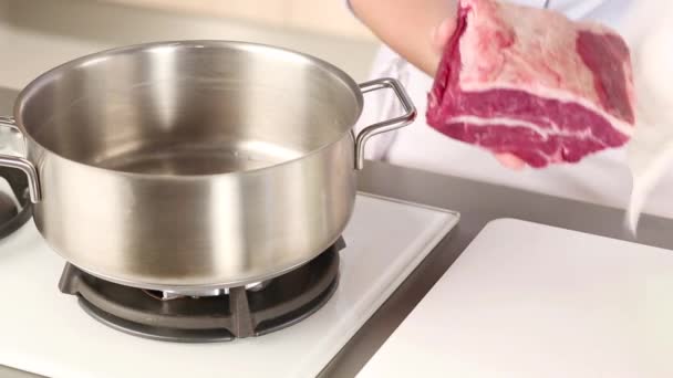 Koud water wordt toegevoegd aan het rundvlees in een pot — Stockvideo
