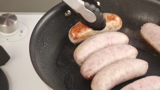 Sausages in a pan being turned — Stock Video