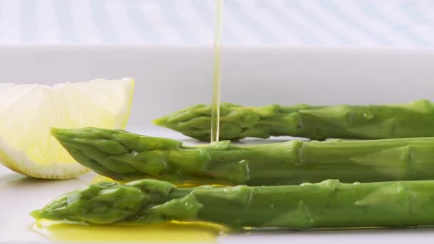 Boter gieten over groene asperges — Stockvideo