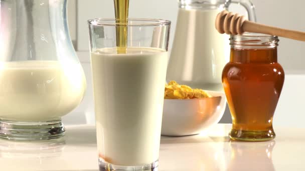 Poner miel en un vaso de leche — Vídeos de Stock