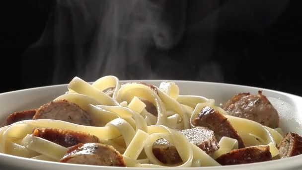 Ribbon pasta with slices of sausage — Stock Video