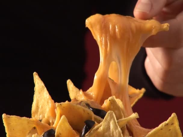 Hand taking nacho with melted cheese — Stock Video